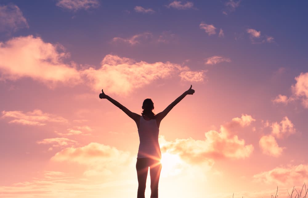 Happy woman giving thumbs up to life